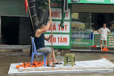 Khu đô thị ở Hà Nội ngập sâu, người dân dùng đệm chở xe máy, đi bè mua cơm