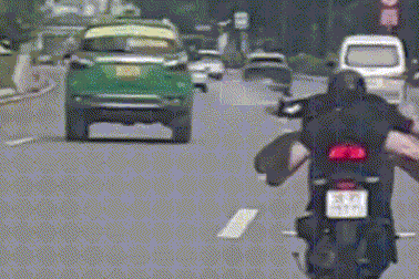Hai thanh niên nằm trên xe máy, lao vun vút trong làn ô tô ở TPHCM