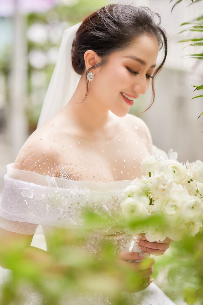 Khánh Thi xuất hiện như một nàng công chúa với đầm trắng đính đá lấp lánh khoe nét đẹp nữ tính.