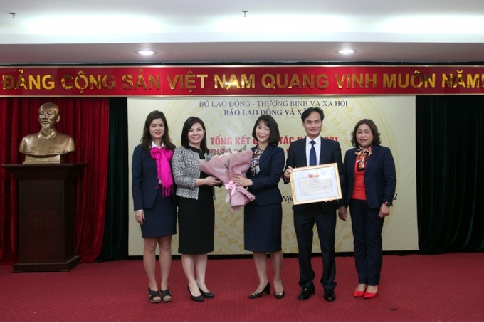 Bà Hoàng Thị Thu Huyền, Chủ tịch Công đoàn Bộ LĐ-TB&XH trao Bằng khen và hoa chúc mừng Công đoàn Báo.
