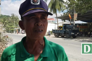 Bác bảo vệ dắt học sinh qua đường có nhiều xe tải