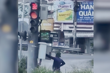 Người trùm kín mít, đứng bấm đèn đỏ ở TPHCM có hành động không chuẩn mực