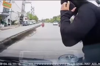 Mải nhìn điện thoại, người đi xe máy ngã đập đầu vào ô tô