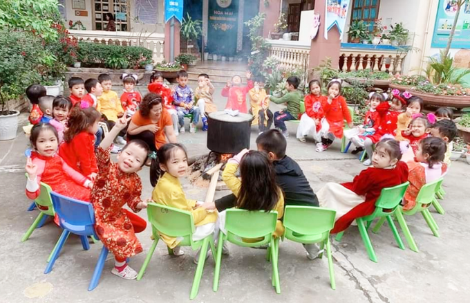 Cô và trò trường mầm non Hoa Mai cùng nhau trải nghiệm gói bánh chưng Tết.