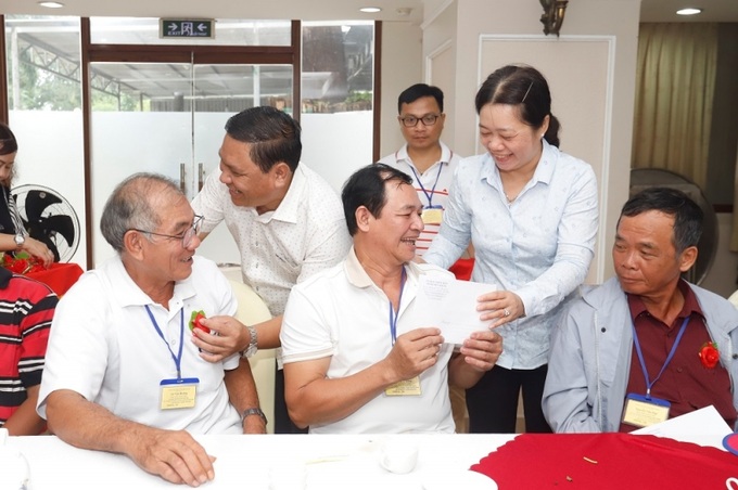 Giám đốc Sở LĐ-TB&XH Lý Văn Cẩm và Phó GĐ Sở LĐ-TB&XH Nguyễn Thị Kiều Loan tặng quà và cài hoa cho NCC.