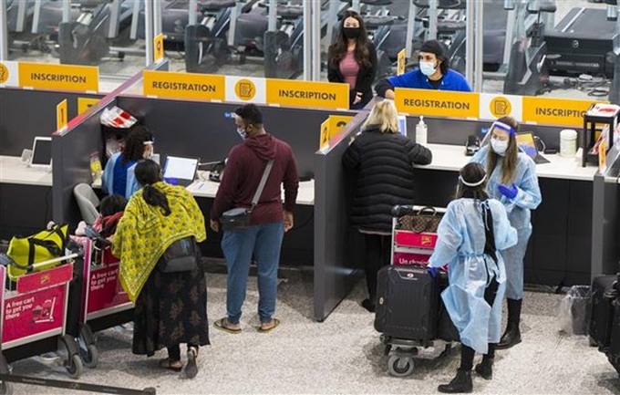 Hành khách đeo khẩu trang phòng lây nhiễm COVID-19 tại sân bay quốc tế Toronto ở Mississauga, Ontario (Canada), hồi đầu năm 2021. Ảnh: THX/TTXVN