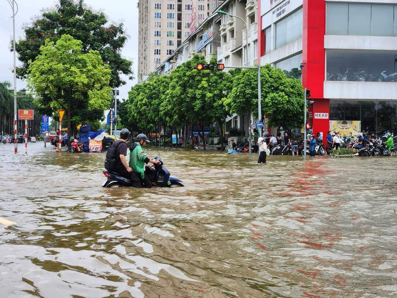 Nước ngập quá nửa thân xe máy khiến người dân khó di chuyển (Ảnh: Dương Tâm).