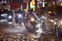 Người dân bì bõm trở về nhà trên con đường cứ mưa là ngập