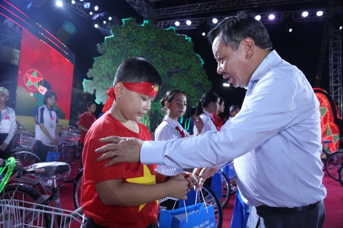 Phó Bí thư Thành ủy Hà Nội Nguyễn Văn Phong trao những phần quà đến tận tay những em nhỏ có thành tích học giỏi.