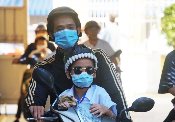 Phụ huynh đưa trẻ đến trường Tiểu học Nguyễn Đình Chiểu, quận Bình Thạnh, ngày 14/2. Ảnh: Mạnh Tùng