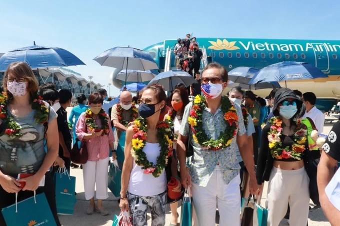 Các hành khách trên chuyến bay đầu tiên trên đường bay Singapore - Nha Trang hào hứng khi được đón tiếp và tặng quà lưu niệm.