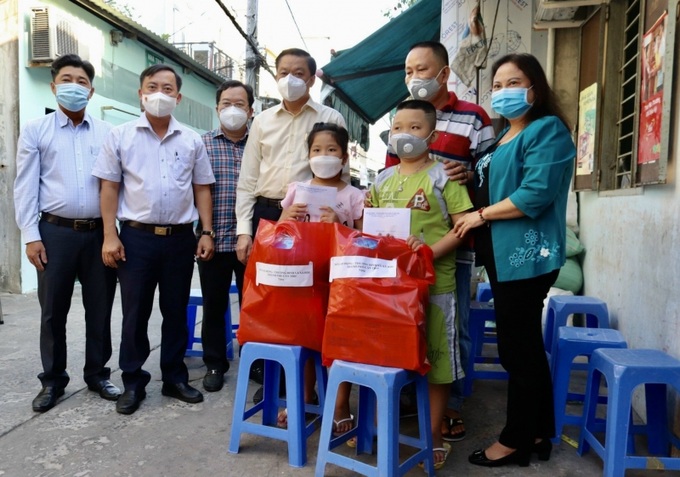 Ông Dương Tấn Hiển, Phó Chủ tịch Thường trực UBND TP Cần Thơ (thứ 3 từ phải sang) cùng bà Trần Thị Xuân Mai - GĐ Sở LĐ-TB&XH TP.Cần Thơ trao quà cho trẻ mồ côi do Covid-19.