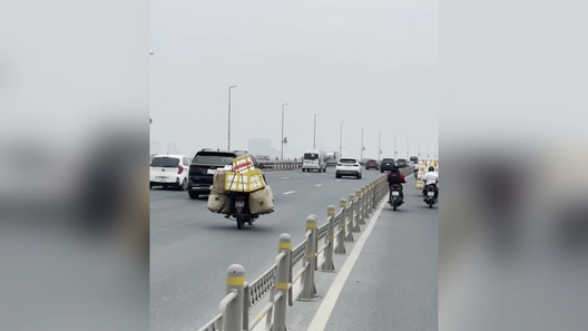 Xe máy bất chấp nguy hiểm chạy vào làn ô tô trên cầu Nhật Tân