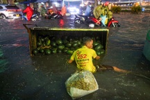 Xe dưa hấu lật nhào ra đường do mưa lớn, đường ngập sâu ở TPHCM