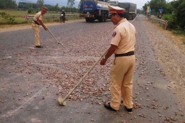 CSGT dọn đá rơi vãi trên đường, đảm bảo an toàn giao thông