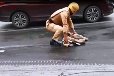 CSGT cặm cụi cầm giẻ lau vết dầu trên đường phố