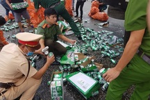 Người dân, công an giúp tài xế xe tải gom nhặt hàng trăm két bia bị rơi