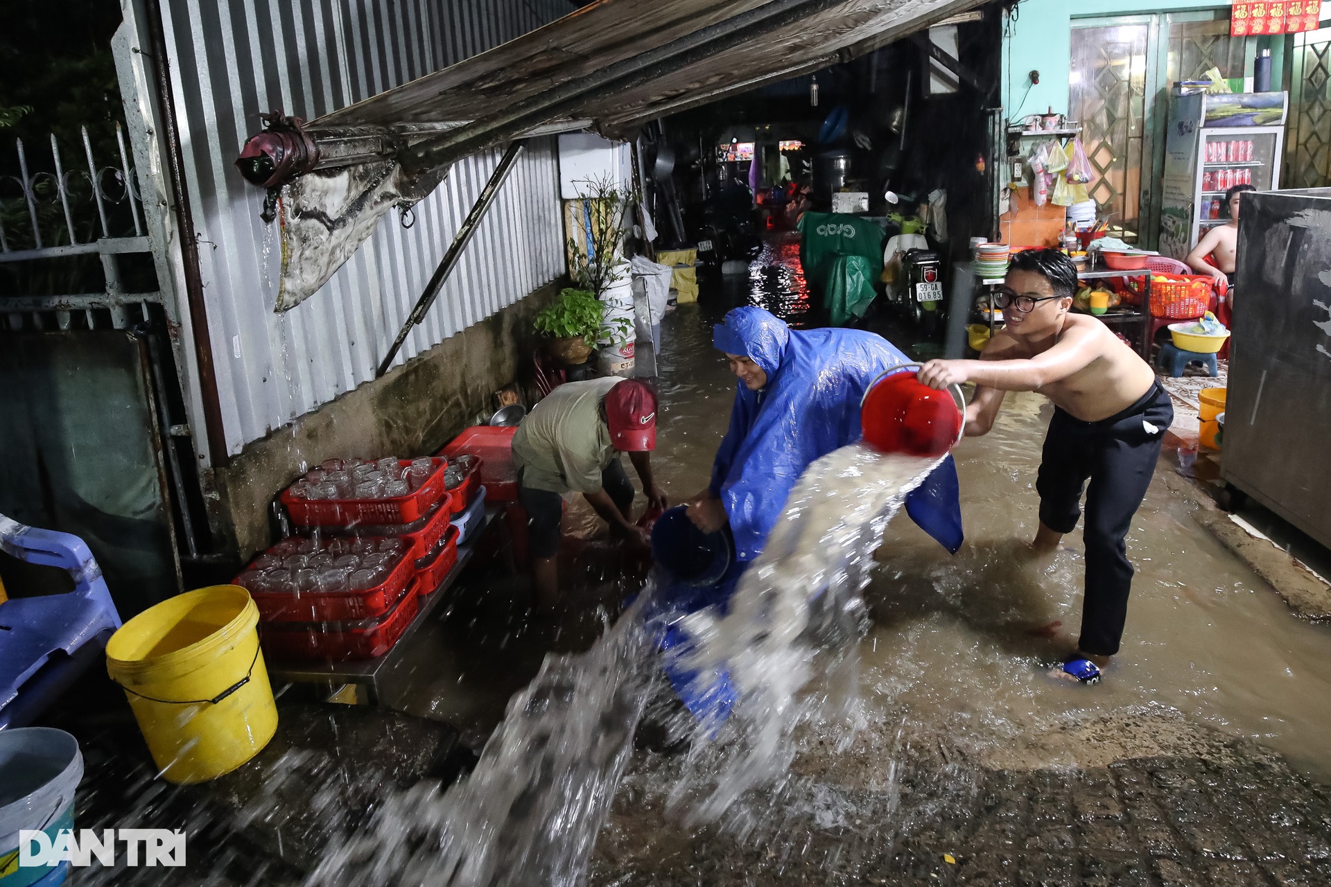 Người dân TPHCM dùng xô tát nước ra khỏi nhà sau cơn mưa lớn - 2