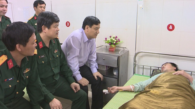Ông Nguyễn Đắc Vinh - bí thư Tỉnh ủy Nghệ An và lãnh đạo Bộ Chỉ huy quân sự Nghệ An thăm hỏi, động viên trung úy Âu - Ảnh: X.HƯỚNG