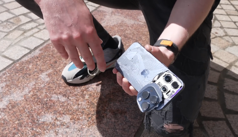 Cụm camera của iPhone 15 Pro bị bung ra sau những màn thả rơi liên tục xuống nền đá cứng (Ảnh chụp màn hình). Cụm camera của iPhone 15 Pro bị bung ra sau những màn thả rơi liên tục xuống nền đá cứng (Ảnh chụp màn hình).