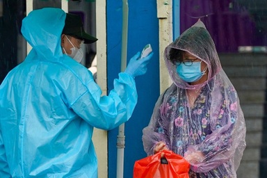 Người dân TPHCM đội mưa lớn đi tiêm vắc xin ngừa Covid-19 đợt 5