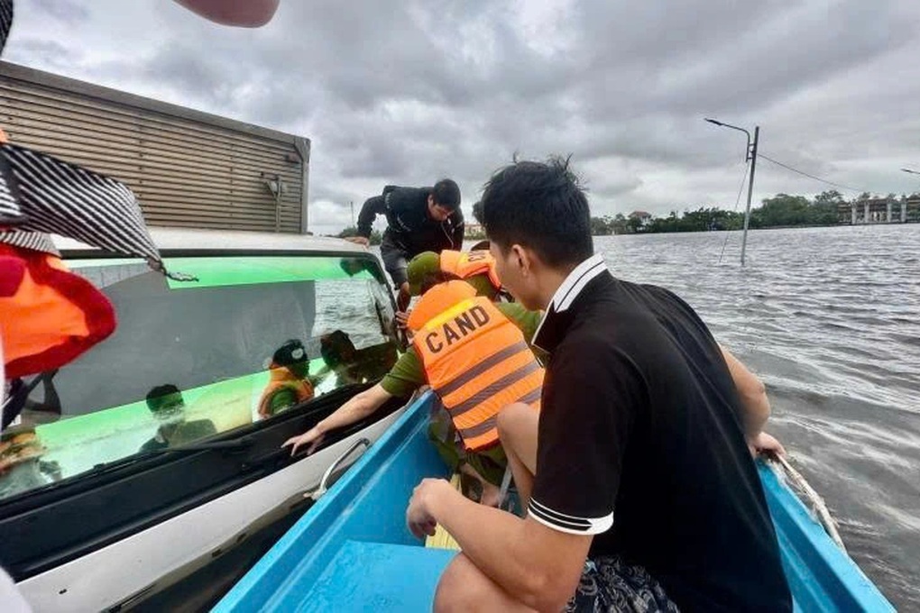 Cố băng qua vùng lũ, xe tải và 2 người mắc kẹt - 1