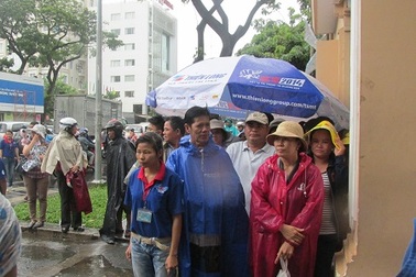 Sinh viên tình nguyện che mưa cho thí sinh