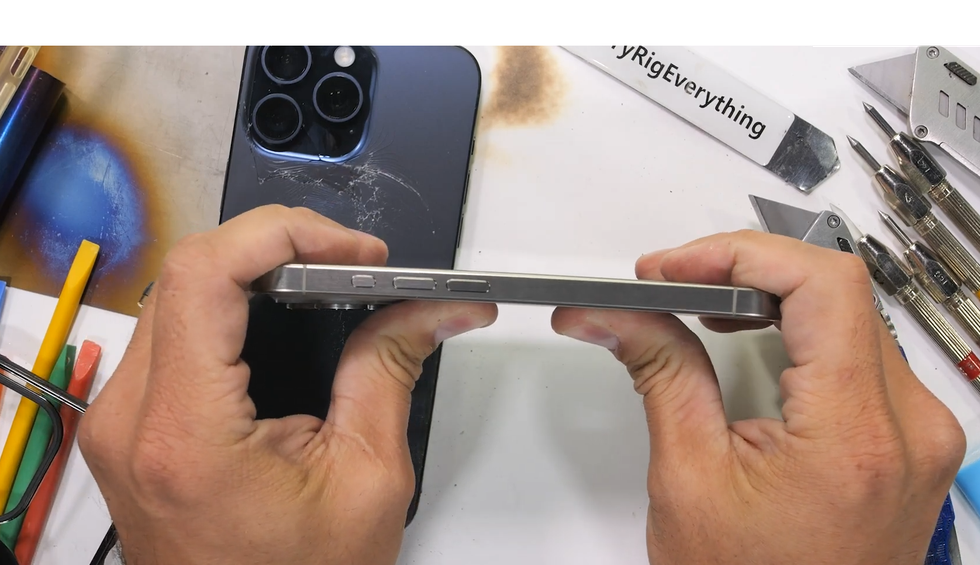 iPhone 15 Pro vẫn bình thường và mặt lưng không bị vỡ khi thử bẻ cong sản phẩm (Ảnh chụp màn hình). iPhone 15 Pro vẫn bình thường và mặt lưng không bị vỡ khi thử bẻ cong sản phẩm (Ảnh chụp màn hình).