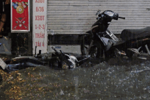 Nước tràn vào nhà xối xả, xe máy nổi lềnh bềnh trong cơn mưa lớn ở Hà Nội