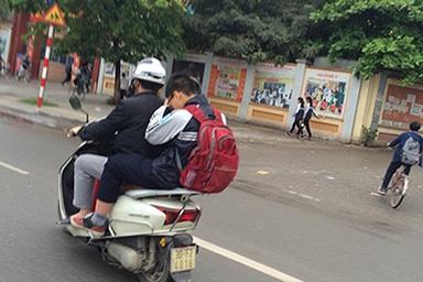 Nhiều phụ huynh vẫn "chống lệnh" đội mũ bảo hiểm cho con