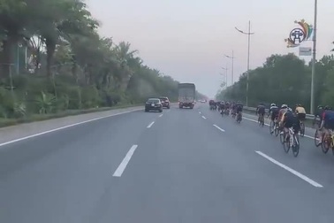 Nhóm người đi xe đạp thể thao nối đuôi nhau đi vào cao tốc