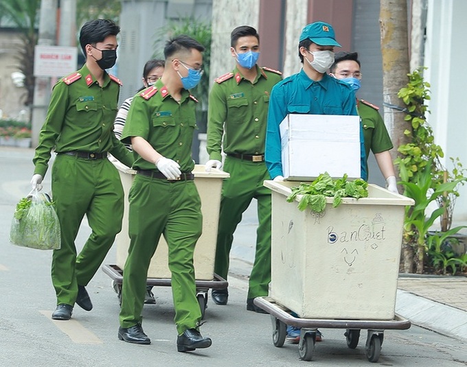 Công an, bảo vệ tổ dân phố đẩy xe phát thực phẩm miễn phí cho người dân Trúc Bạch đang bị cách ly - Ảnh 1. Công an, bảo vệ tổ dân phố đẩy xe phát thực phẩm miễn phí cho người dân Trúc Bạch đang bị cách ly - Ảnh 1.