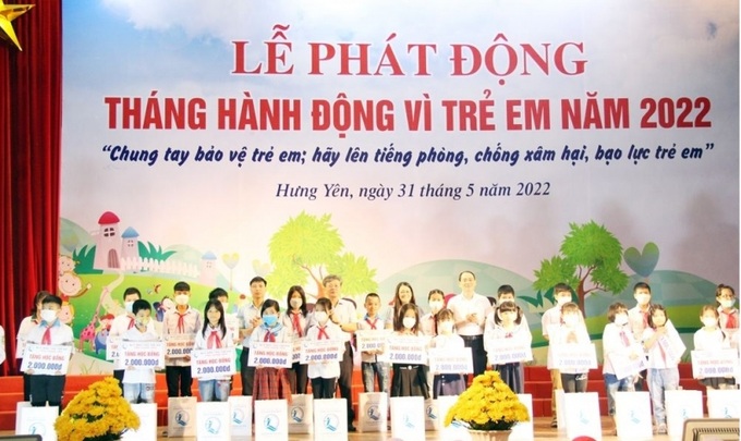 Các đại biểu trao học bổng và quà của Quỹ Bảo trợ trẻ em tỉnh tặng trẻ em có hoàn cảnh khó khăn đạt thành tích cao trong học tập, rèn luyện.