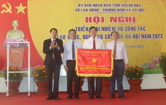 Ông Đinh Văn Thiệu-Phó Chủ tịch UBND tỉnh Khánh Hòa (trái) trao tặng Cờ thi đua xuất sắc của Bộ LĐ-TB&XH cho tập thể Sở LĐ-TB&XH tỉnh Khánh Hòa