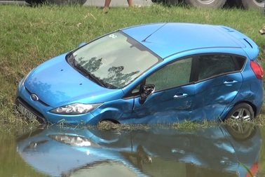 Xe container húc bay xe 4 chỗ xuống mương nước