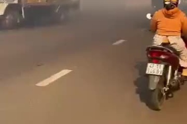 Người dân hoảng sợ khi di chuyển qua đường đầy khói đen do đốt rác