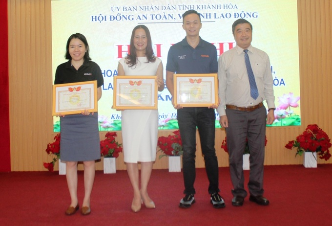 Ông Tạ Hồng Quang-Giám đốc Sở LĐ-TB&XH tỉnh Khánh Hòa (bìa phải) khen thưởng cho các tập thể, cá nhân xuất sắc trong công tác ATVSLĐ