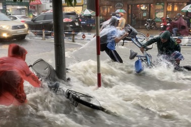 TPHCM: Mưa như trút, nước cuốn trôi xe đạp học sinh giờ tan trường