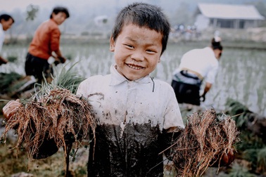 Nụ cười hồn nhiên của em bé Y Tý lấm lem bùn đất