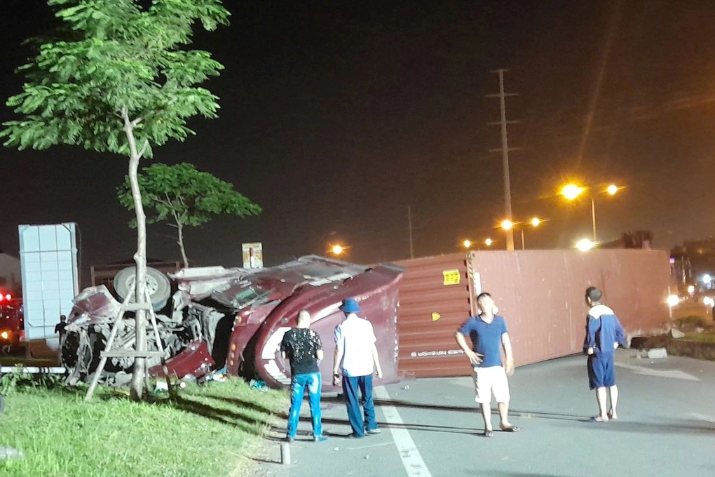 Xe container lật ngang đường, tài xế mắc kẹt trong cabin - 1 Xe container lật ngang đường, tài xế mắc kẹt trong cabin - 1