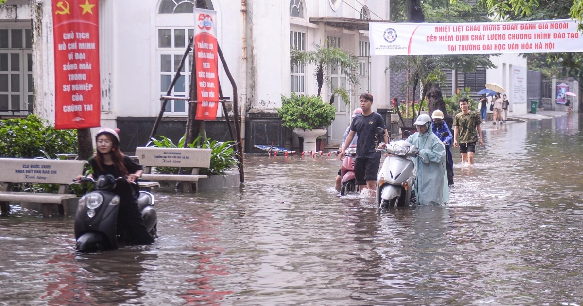 Sân trường đại học ở Hà Nội lênh láng nước, sinh viên bì bõm dắt xe