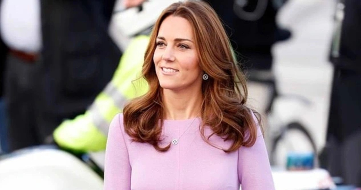 Công nương Kate Middleton diện váy midi màu tím, thiết kế tay bồng với phần ngực được trang trí bằng kỹ thuật xếp nếp tạo điểm nhấn. Công nương chọn đôi giày mũi nhọn màu nude cùng kiềng tay và hoa tai ánh vàng kết hợp với chiếc nhẫn kim cương và đá sapphire đắt giá. Cô trang điểm nhẹ nhàng, gương mặt luôn tươi cười rạng rỡ (Ảnh: Getty Images).