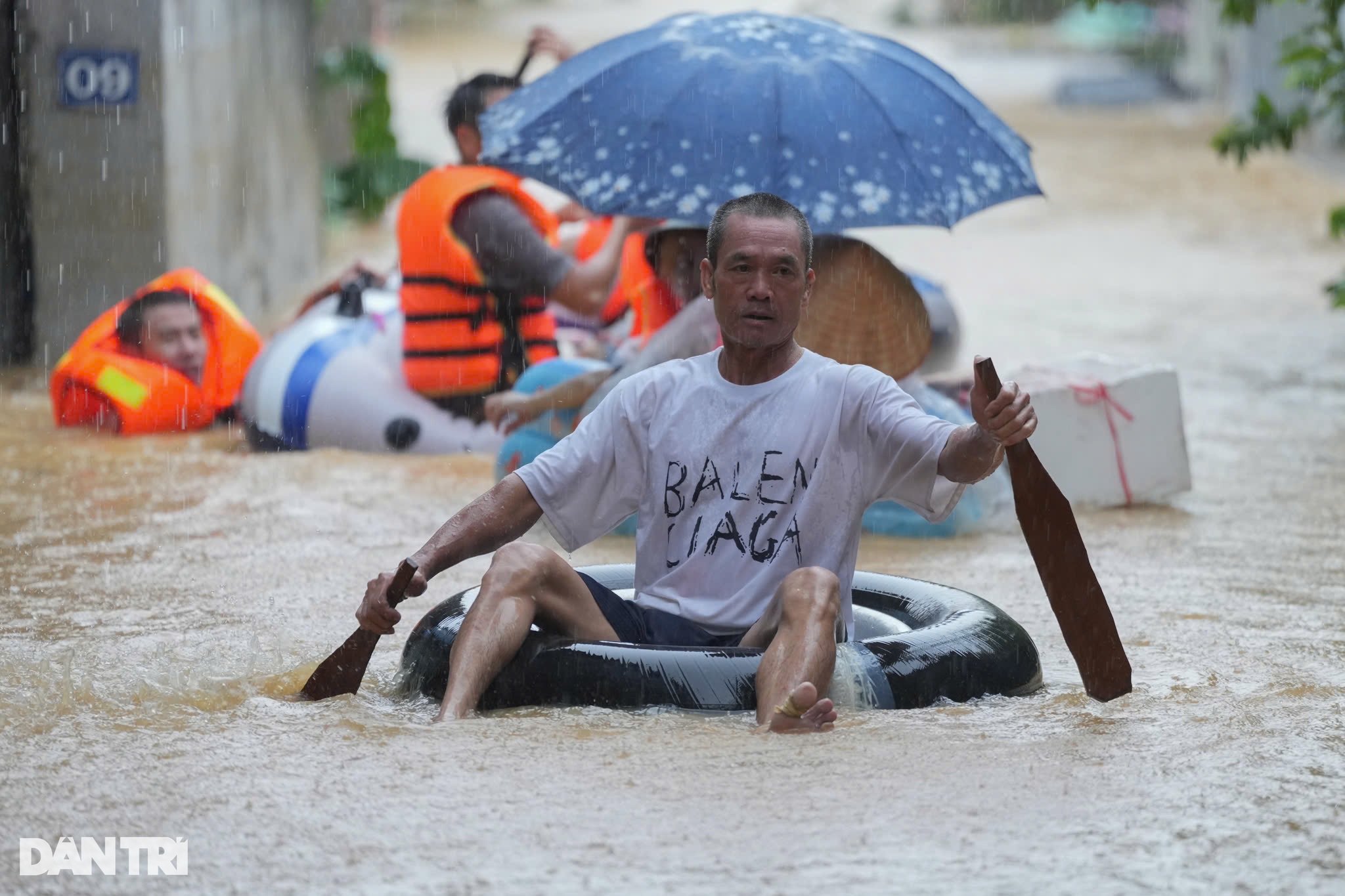 Ông Nguyễn Hữu Phú chèo bè tự chế đi nhận lương thực (Ảnh: Hữu Khoa).