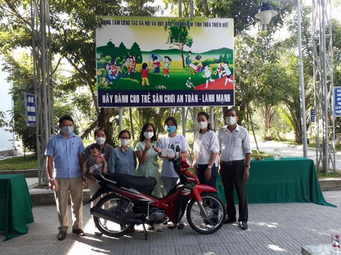 Lãnh đạo Trung tâm Công tác xã hội và Quỹ Bảo trợ Trẻ em tỉnh Thừa Thiên Huế và các nhà hảo tâm trao tặng chiếc xe máy, làm phương tiện đi lại cho em Lê Thị Thanh Nhàn.