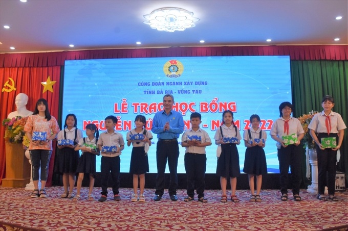 Các em học sinh nhận học bổng và quà tại buổi lễ.