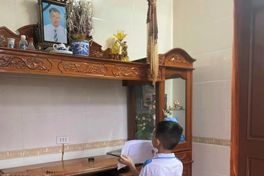 Xúc động hình ảnh cậu bé lớp 1 khoe giấy khen trước di ảnh bố