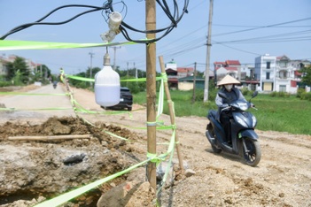 Lắp bóng đèn cảnh báo sau vụ xe máy lao xuống hố sâu trên đường ở Hà Nội