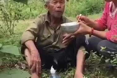 Người phụ nữ mang cơm lên núi bón cho cụ già đi lạc