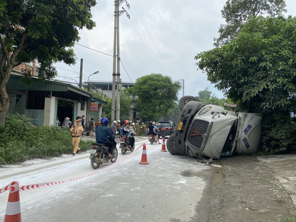 Lật xe đầu kéo, hàng trăm lít axit bị tràn ra đường - 1 Lật xe đầu kéo, hàng trăm lít axit bị tràn ra đường - 1