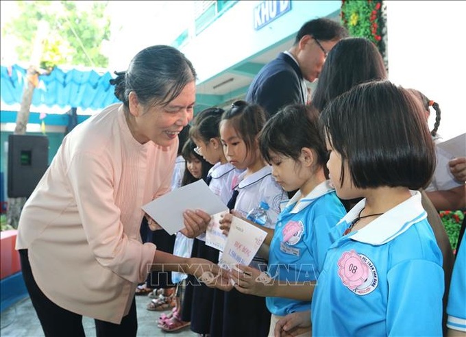 Bà Nguyễn Thị Thanh Hòa, Chủ tịch Hội Bảo vệ Quyền trẻ em Việt Nam tặng học bổng và quà cho các em học sinh có hoàn cảnh khó khăn tại chương trình. Ảnh: TTXVN